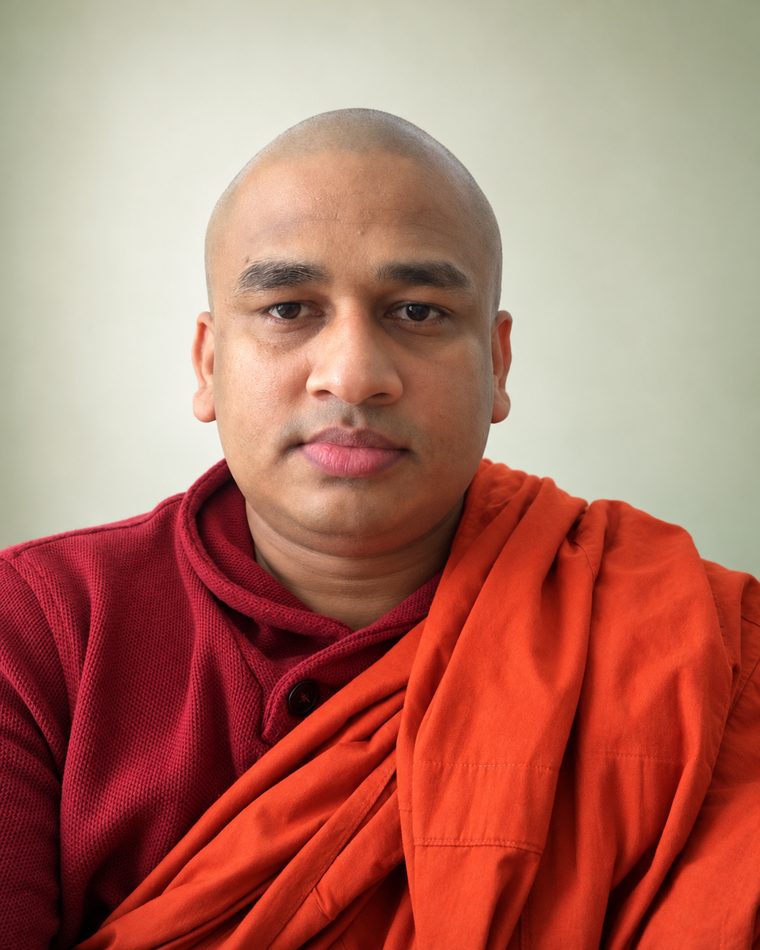 Portrait of Bhante Chandananda Kirinde in an orange robe